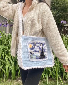 a woman is holding a crocheted purse