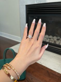 a woman's hand with white manicures and a ring on her finger