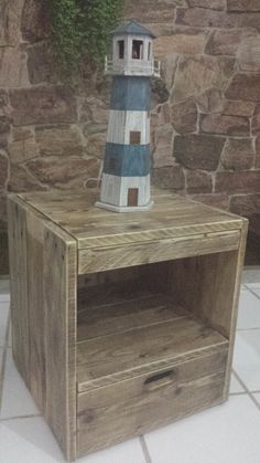 a small wooden table with a blue and white lighthouse on top