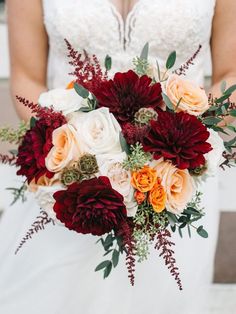 a bridal holding a bouquet of red and white flowers