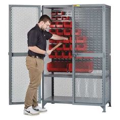 a man standing in front of a large metal storage cabinet with red boxes on it