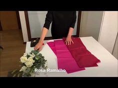 a woman is cutting fabric on top of a table