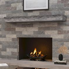 a fire place in a living room with a stone fireplace and mantel above it