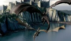 a large dragon flying over a body of water next to a tall building on top of a hill