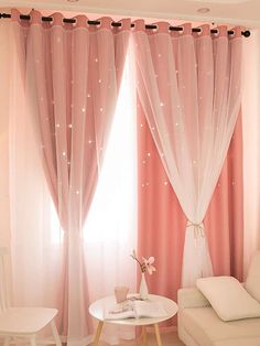 a living room with pink curtains and white furniture