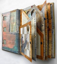 an open book with pages cut out and stacked on top of each other in front of a white wall