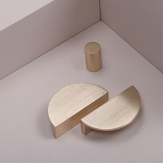 two pieces of metal sitting on top of a white floor next to a round object