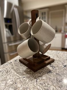 several cups are stacked up on a wooden stand