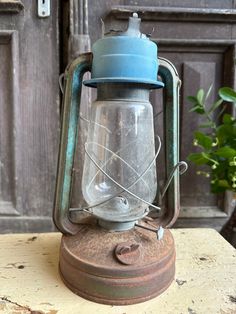 an old fashioned lantern sitting on top of a wooden table