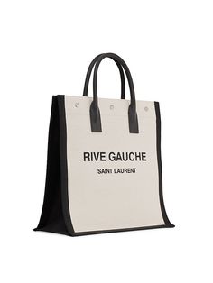 Find SAINT LAURENT Rive Gauche Tote Bag on Editorialist. Saint Laurent's classic tote is crafted entirely of canvas. It features a two-tone motif with the words 'Rive Gauche,' a reference to the southern bank of the river Seine in Paris. The tote has dual top handles. It is made in Italy. Saint Laurent Rive Gauche Tote, River Seine, Rive Gauche, The River, Two Tone, Saint Laurent, Handles, In Italy, Tote Bag