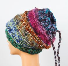 Colorful headband made of a mixture of different types of yarns (wool, acrylic). Made with knitting needles. Top tightened with a yarn drawstring.   The headband is wide, medium thickness, warm, for curls, buns, dreadlocks.   Size 54 - 58 cm, width 24 cm without stretching. Due to the mix of different types of wool and acrylics, the hat can be biting on the skin in places. All my hats are seamless, in a single copy, designed and made by me. The actual colors may differ from their appearance on t Multicolor Bohemian Knitted Beanie, Bohemian Hand Knitted Beanie, Handmade Bohemian Yarn Beanie, Handmade Bohemian Beanie From Yarn, Multicolor One Size Headband Hat, Bohemian Hand Knitted Multicolor Beanie, Bohemian Multicolor Hand Knitted Beanie, Bohemian Multicolor Hand-knitted Beanie, Handmade Yarn Headband, One Size