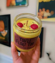 a person holding up a jar of food in their hand