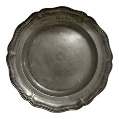 an antique silver plate with writing on the bottom and sides, possibly made in england