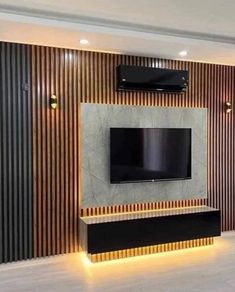 a living room with a flat screen tv mounted on the wall and wooden paneling