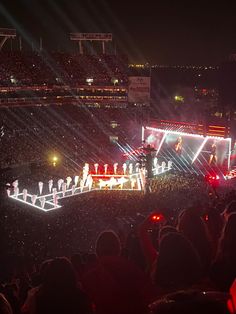 a large group of people standing on top of a stage in front of a crowd