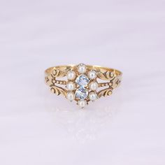 What a remarkable ring! This antique 9-10K gold carved ring features 8 seed pearls and 2 modern replacement round aquamarines. It is lightweight, so not recommended for daily wear. Save her for special occasions to elevate your look!   This antique ring is in good wearable condition, it does show some normal wear, and old marks inside the ring of a trefoil and a W. It comes in a size 8, but it can be sized up or down for you! Heirloom Yellow Gold Multi-stone Diamond Ring, Victorian Oval Pearl Ring With Gemstone, Antique Multi-stone Yellow Gold Jewelry, Antique Yellow Gold Multi-stone Jewelry, Antique Yellow Gold 14k Pearl Ring, Antique Oval Multi-stone Ring, Victorian Gold Sapphire Ring With Diamond, Antique Gold Pearl Ring In 14k Gold, Victorian 14k Yellow Gold Pearl Ring