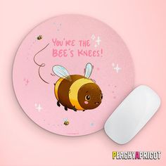 a pink mouse pad with a cartoon bee on it next to a white computer mouse