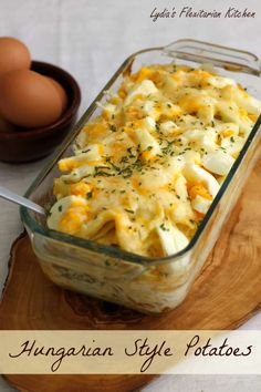 a casserole dish with eggs and cheese in the background on a wooden table