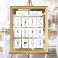 a wooden easer holding a table number and seating chart for a wedding or event