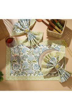 a table setting with napkins, place mats and utensils on the table