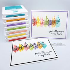 four cards with music notes on them and some colored crayons in the background