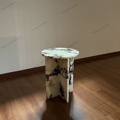 a marble table sitting on top of a hard wood floor