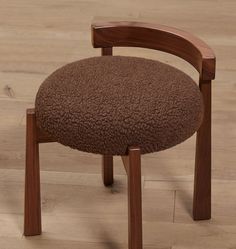 a wooden chair with a brown upholstered seat and wood frame on the floor