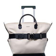 a white bag with black straps and handles