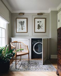 a washer and dryer in a room with pictures on the wall above it