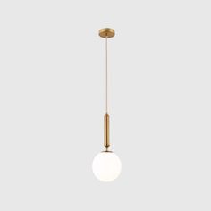 the brass and glass pendant light fixture is hanging from an angled rod, with a white ball on it