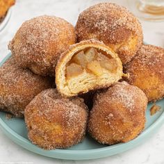 a blue plate topped with donuts covered in powdered sugar on top of a table