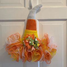 an orange and yellow mesh wreath on the front door