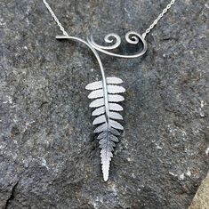 Sterling silver fern necklace created from a real fern frond. This necklace was made using a process called roll printing. A real leaf is pressed and dried before its impression is roll printed onto metal sheet.  I collect and press leaves from trees and small saplings each spring when they first emerge and are the perfect size for creating jewelry. The 'stem' and scroll designs are made from 14 gauge sterling silver wire and feature hand hammered texture. This necklace is one of a kind because each leaf can only be roll printed once since its veins are completely flattened in the process. The closure is a sterling silver spring clasp. Fern Necklace, Fern Frond, Real Leaf, Pressed Leaves, Silver Fern, Real Leaves, Metal Sheet, Creating Jewelry, Scroll Design