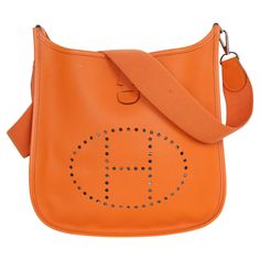 Authentic, pre-loved Hermes Orange Leather Evelyne I Shoulder Bag. Features a perforated logo display on the front, and a flat shoulder strap, the bag can be worn comfortably over the shoulder. The upper opening is secured with the help of a snap closure. An absolute classic in a variant that offers space for all things of every day. Strap drop: 20" Stamp reads: [Engraving]□1 11.0"L x 2.75"W x 11.75"H Condition Gently used Beautiful condition, the interior has small stains, the strap is strong a Luxury Bags With Perforations For Daily Use, Designer Leather Bags With Perforations, Leather Bag With Perforations For Daily Use, Leather Bags With Perforations For Everyday Use, Leather Shoulder Bag With Perforations, Luxury Perforated Shoulder Bag, Hermes Orange, Louis Vuitton Crossbody Bag, Louis Vuitton Crossbody