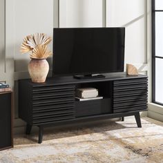 an entertainment center with a large television on it's stand in front of a window