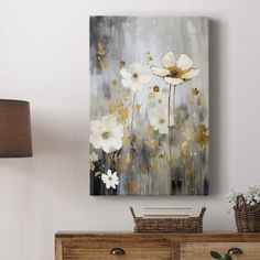 an abstract floral painting hangs on the wall above a dresser in a white living room