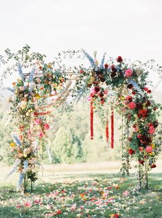 an outdoor wedding ceremony with flowers and greenery