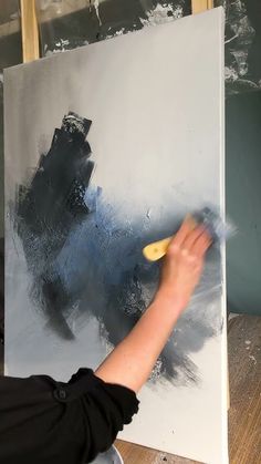 a person is painting on a large canvas