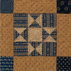 a close up of a quilt with blue and brown squares on it's sides