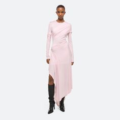 Long-sleeved dress in lyocell jersey. The translucent knit becomes opaque underneath draped panels that wrap around the body, creating a sense of movement and allowing for flashes of exposed skin. Draped Jersey Dress, Winter Pink Dress, Jersey Draping, Long Jersey Dress, Jersey Shirt Dress, Beach Wedding Guest Dress, Garment Manufacturing, Dress Drape, Denim T Shirt