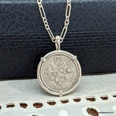 This vintage Elizabeth II English Sixpence rests in a handcrafted setting made of recycled sterling silver wire. I make each setting by hand separately from the coin. The coin does not have a hole drilled in it or any metal soldered to its edge. The handmade setting is sturdy and allows the coin to be worn as a charm on a bracelet. The setting is stamped with both my maker's and metal purity (925) mark on the bail's interior. The obverse of the coin features a portrait of Elizabeth II by Mary Gi Silver Coin Pendant Necklace, Vintage Jewelry Display, Silver Coin Necklace, Custom Coins, Mens Silver Jewelry, Tudor Rose, Silver Link Chain, Gold Jewelry Stores, Coin Pendant Necklace