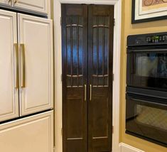 an oven and microwave in a kitchen next to each other, with the door ajar