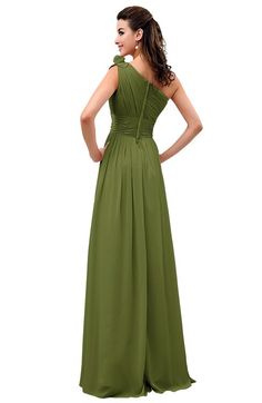 a woman in a long green dress with her back to the camera, looking down