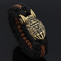 The Preferred Disguise Of Gods During visits to the human world, Odin as well as Thor often takes on the appearance of bear as a disguise. Therefore, bears tend to be looked upon as the forefathers of man in ancient times. Bears symbolize wisdom, strength, and healing that bring balance to seen and the unseen world. This bracelet features a bear paw accent with a Runic inscription at its front face. This type of bracelet is a Paracord bracelet which are also known as survival bracelets and is co Black Viking Jewelry For Outdoor, Black Viking Style Jewelry For Outdoor, Black Viking Style Outdoor Jewelry, Adjustable Black Viking Bracelet, Adjustable Black Bracelet For Collectible, Adjustable Black Bracelet For Collectors, Norse People, Paracord Braids, Iron Jewelry