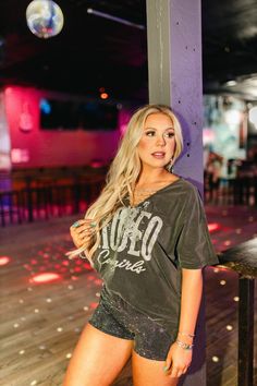 Our Rodeo Cowgirls Chain Neck Graphic Tee is a rodeo-ready statement! The chain neck detail adds a touch of edgy flair, while the graphic pays homage to the fearless spirit of rodeo cowgirls. Whether you're out on the town or just kicking back, let this tee be your go-to for a perfect blend of comfort and cowgirl chic. Runs very large - can be styled as a t-shirt dress too! Rodeo Cowgirl, Womens Jumpsuits, Cowgirl Chic, Rodeo, Black Tee, T Shirt Dress, Jumpsuits For Women, Graphic Tee, Jumpsuit Romper