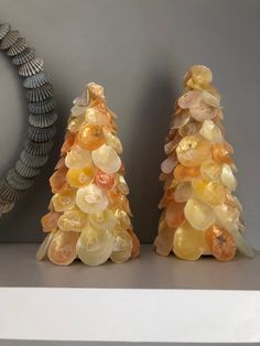 two glass christmas trees sitting on top of a shelf