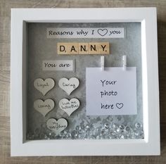 a white frame with some magnets on it and paper hearts attached to the side