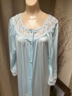 If you love anything in a soft aqua blue color you might fall in love with this pretty robe.   No indication it was ever worn.   Lightweight nylon is comfy and easy to wear.   Popular Gilead lingerie that you might have in your collection already. A  wide dyed to match lace section about the bust and on the 3/4 sleeves.  A bit of fullness in the sleeves. Buttons down the front. Single seam pocket. Nice fullness front and back. Wash in a mesh lingerie bag cool delicate cycle and hang to dry.  Onl Long Sleeve Blue Nightgown For Home, Blue Nightgown For Spring, Blue Spring Nightgown For Overnight, Light Blue Nightgown For Home, Light Blue Long Sleeve Nightgown For Spring, Blue Spring Robe For Home, Blue Home Robe For Spring, Blue Spring Home Robe, Fitted Light Blue Nightgown For Loungewear