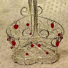 a metal wire basket with red apples on the top and bottom, sitting on concrete