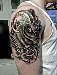 a man with a goat tattoo on his arm and shoulder, holding a rose in front of him